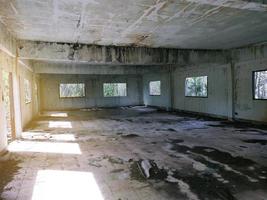 edificio abbandonato stanza abbandonata con pareti incrinate e vernice scrostata c'è acqua all'interno dell'orrore. foto