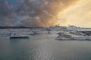 laguna glaciale scenica di jokulsarlon con la montagna sullo sfondo durante il tramonto foto