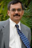 un uomo d'affari indiano con gli occhiali e un abito azzurro foto
