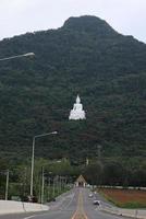 il punto di vista di fronte al buddha bianco si trova nel mezzo di una collina verde della foresta. wat phra khao a nakhon ratchasima, Thailandia, il 16-05-2022 foto