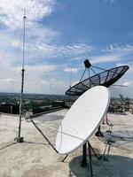una parabola satellitare è installata sul tetto di una sala macchine all'ultimo piano di un alto edificio. a bangkok, tailandia foto