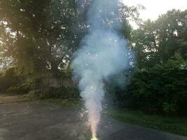 fuochi d'artificio colorati accesi sul vialetto di asfalto con il fumo foto