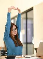 la donna allunga le braccia quando è stanca in ufficio, la donna d'affari si rilassa, la sindrome dell'ufficio. foto