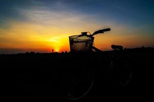 silhouette di bicicletta su un tramonto foto