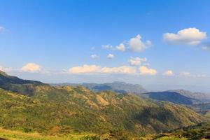 prato di montagna con nuvole e cielo blu foto