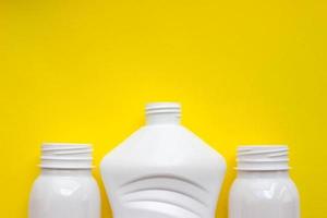 bottiglie di plastica bianche su sfondo giallo con posto per il tuo design. vista dall'alto foto