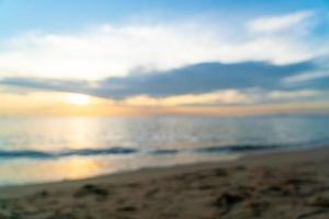 sfocatura astratta bellissima spiaggia tropicale e mare con cielo al crepuscolo all'ora del tramonto foto