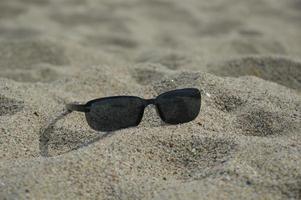 occhiali da sole sulla spiaggia foto