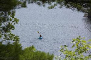giovane donna in kayak, acqua in sunapee, New Hampshire, Horizonta foto