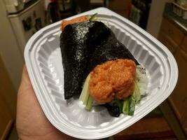 mano che tiene involtini di tonno speziato sushi cibo giapponese foto