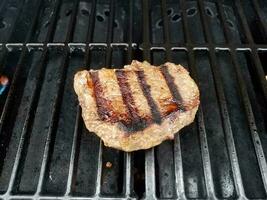 bistecca di manzo che cucina sulla griglia del barbecue calda foto