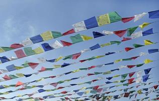 bandiere di preghiera tibetane che volano nel vento in una giornata di sole foto