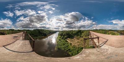 panorama completo a 360 gradi senza soluzione di continuità in proiezione equidistante sferica equirettangolare. vista panoramica sul ponte di abbandono vicino al fiume con belle nuvole. skybox come sfondo per i contenuti di realtà virtuale foto