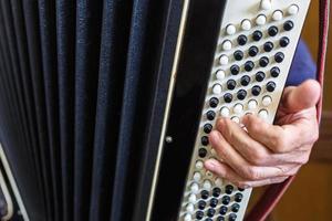 mano del musicista che suona il primo piano delle fisarmoniche foto