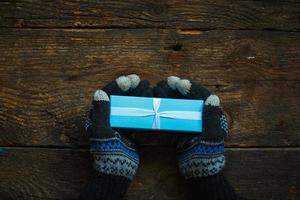 mani in guanti invernali con confezione regalo di Natale foto