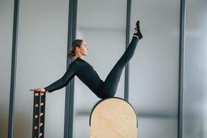 utilizzando attrezzature speciali. la donna in abiti sportivi è in studio foto