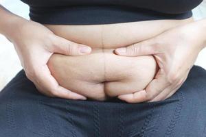 le donne gli sporgevano lo stomaco e lo toccavano con le mani. foto