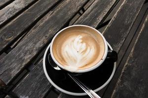 latte caldo sul vecchio tavolo di legno foto