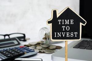 tempo per investire il testo sul modello di casa in legno. concetto di investimento immobiliare. foto