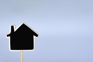 modello di casa in legno su sfondo blu. concetto di business e immobiliare. foto