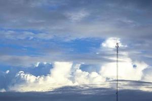 cieli grigi, nuvole multicolori e alti pali del telefono la sera. i cieli sono cupi come una tempesta e la tecnologia moderna nel mondo del futuro. foto