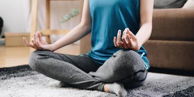 classe di yoga con le mani meditate dell'asia donna che fa meditazione sanitaria, concetto di stile di vita. fitness fisico nazionale e mese dello sport. mese nazionale di sensibilizzazione sullo yoga foto