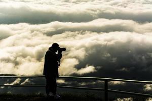 fotografo silhouette nera con nebbia con montagna, mare di mis foto