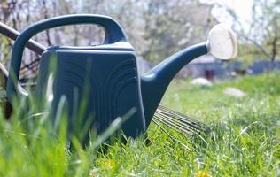 vaso di plastica blu per l'irrigazione in giardino. può annaffiare. annaffiatoio per fiori in strada, in giardino o in giardino in una calda giornata di sole estivo. foto