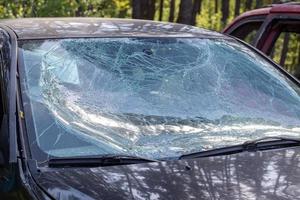 primo piano di un'auto con un parabrezza rotto dopo un incidente. pericolo automobilistico. guida pericolosa e spericolata. un'auto dopo un incidente mortale con un pedone. ucraina, irpen - 12 maggio 2022. foto