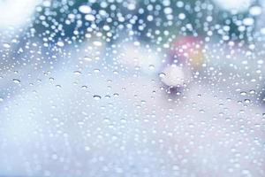 sfondo sfocato di gocce di pioggia sul parabrezza dell'auto foto