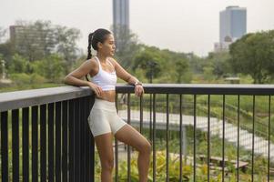 ritratto di giovane donna fitness in abbigliamento sportivo nel parco cittadino, sano e stili di vita. foto