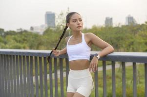 ritratto di giovane donna fitness in abbigliamento sportivo nel parco cittadino, sano e stili di vita. foto