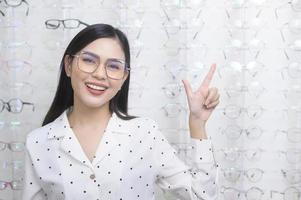 giovane cliente femminile che sceglie gli occhiali nel centro ottico, concetto di cura degli occhi. foto
