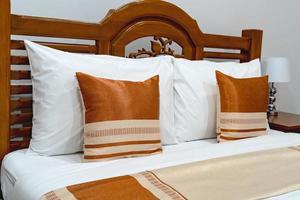 cuscini marroni sul letto di legno foto