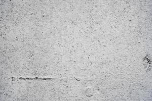 trama di un muro di cemento con crepe e graffi che possono essere utilizzati come sfondo foto