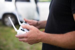 controllo del quadricottero da un joystick con antenne esterne. riprese video dall'alto in volo da un elicottero, tecnologia sullo schermo dello smartphone. foto