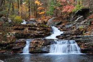 cascata d'autunno in montagna con fogliame foto