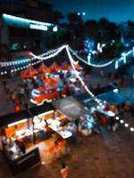 immagini sfocate della festa del cibo delle strade notturne della Tailandia in città, luce del bokeh, fondo del festival. foto