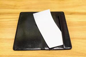 carta bianca vuota in bianco nella cartella della ricevuta di fatturazione del pagamento del ristorante sul tavolo di legno foto