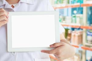 farmacista che mostra tablet computer con il negozio di farmacia foto