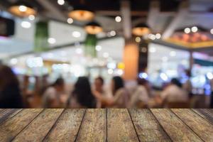 piano d'appoggio in legno con persone nel ristorante con luce bokeh sfocato sfondo astratto cliente foto