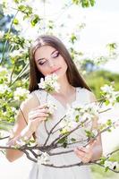 bella ragazza in un giardino di fiori di ciliegio foto