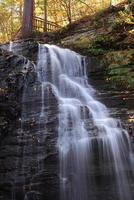 cascata d'autunno in montagna con fogliame e boschi foto