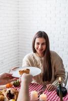 donna e uomo che mangiano la cena del ringraziamento nella cucina di casa foto