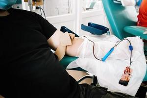 giornata internazionale della donazione di sangue. l'uomo dona sangue in laboratorio medico. foto