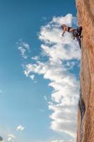 la ragazza sportiva è impegnata nell'arrampicata su roccia foto