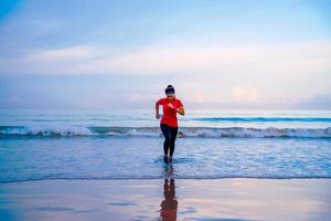 ragazza in esecuzione allenamento jogging sulla spiaggia al mattino. rilassati e felici di correre sul mare. in estate foto