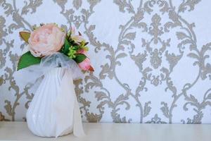 bouquet di fiori in un vaso bianco sul tavolo foto