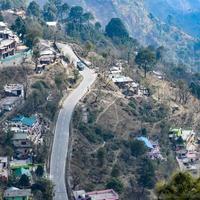 vista aerea dall'alto dei veicoli stradali che guidano su strade di montagna a nainital, india, uttarakhand, vista dal lato superiore della montagna per il movimento di veicoli stradali foto