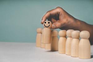 scegliere a mano persona bambola di legno concetto di leadership e business team creativo foto